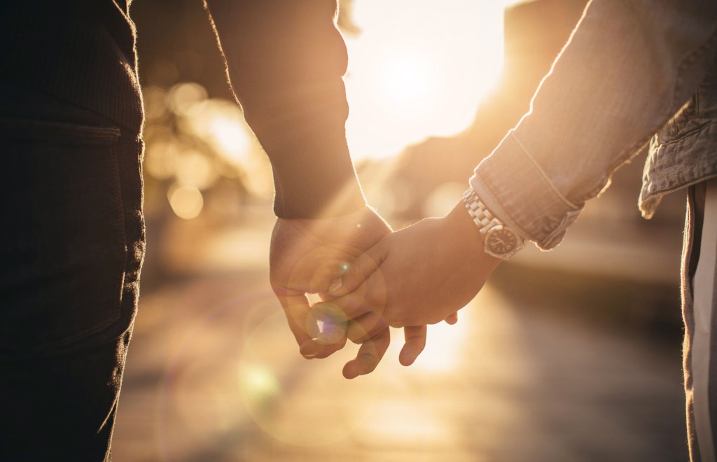 Couple holding hands at sunset