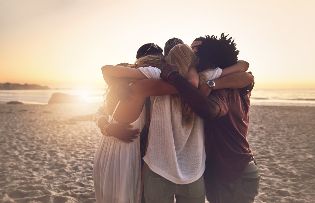 Group embracing at sunset on the beach